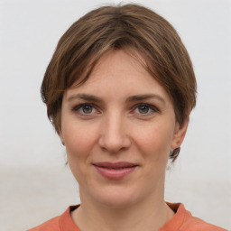 Joyful white young-adult female with medium  brown hair and grey eyes