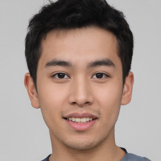 Joyful asian young-adult male with short  brown hair and brown eyes