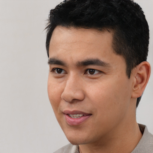 Joyful asian young-adult male with short  black hair and brown eyes