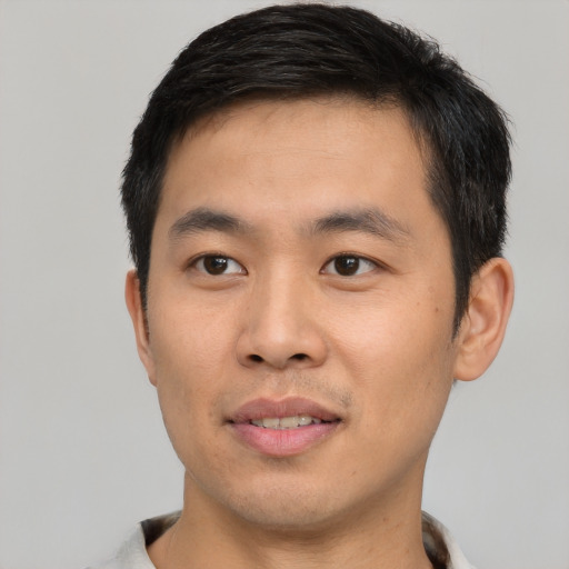 Joyful asian young-adult male with short  black hair and brown eyes