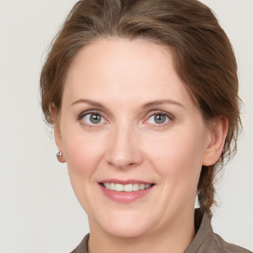 Joyful white young-adult female with medium  brown hair and grey eyes