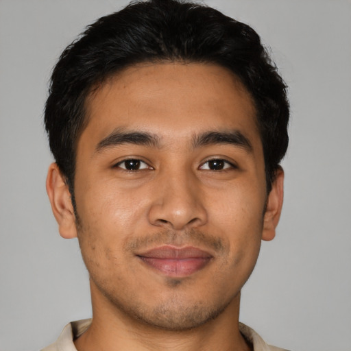 Joyful latino young-adult male with short  brown hair and brown eyes