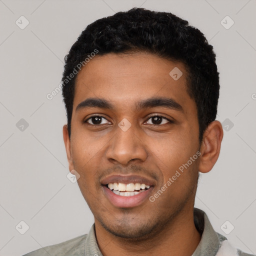 Joyful black young-adult male with short  black hair and brown eyes