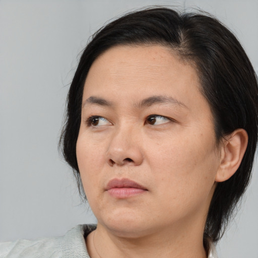 Neutral asian adult female with medium  brown hair and brown eyes
