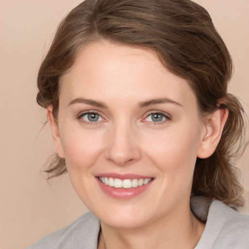 Joyful white young-adult female with medium  brown hair and grey eyes