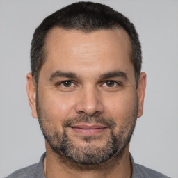 Joyful white adult male with short  brown hair and brown eyes