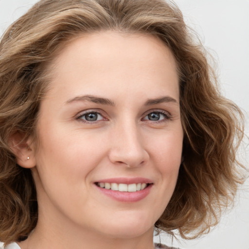 Joyful white young-adult female with medium  brown hair and blue eyes