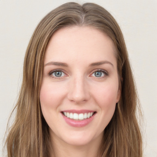 Joyful white young-adult female with long  brown hair and green eyes