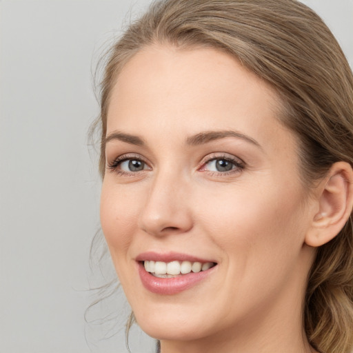 Joyful white young-adult female with long  brown hair and blue eyes