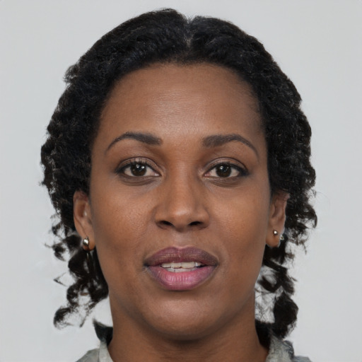 Joyful black adult female with long  brown hair and brown eyes