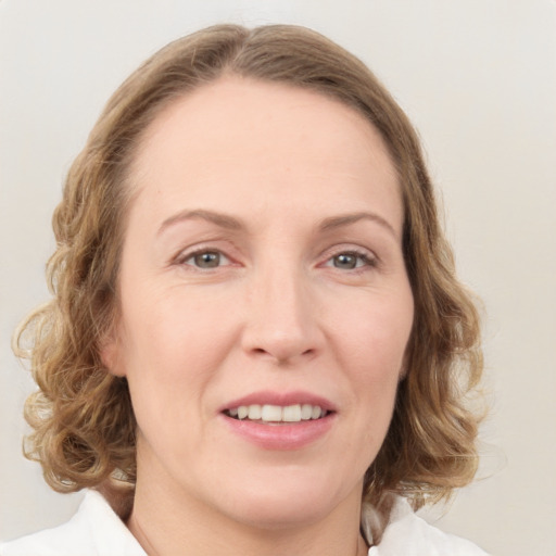 Joyful white young-adult female with medium  brown hair and green eyes