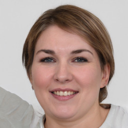 Joyful white young-adult female with medium  brown hair and blue eyes