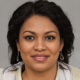 Joyful latino young-adult female with medium  brown hair and brown eyes