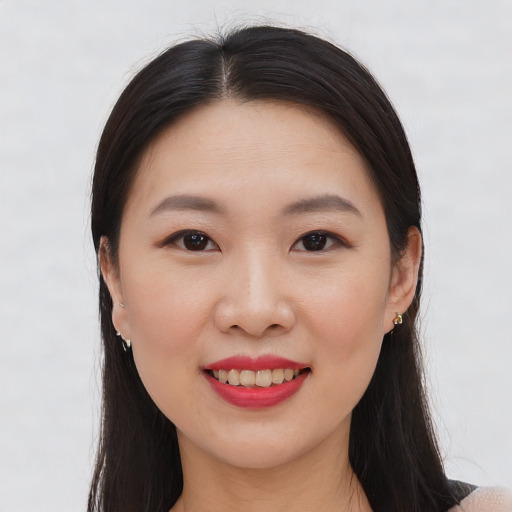 Joyful asian young-adult female with long  brown hair and brown eyes