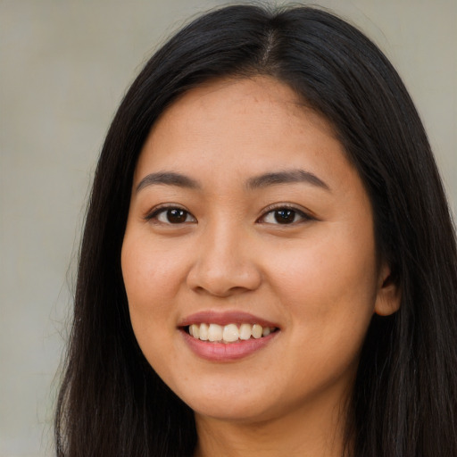 Joyful latino young-adult female with long  brown hair and brown eyes