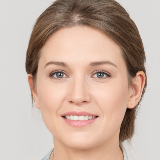 Joyful white young-adult female with medium  brown hair and grey eyes