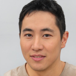 Joyful asian young-adult male with short  black hair and brown eyes