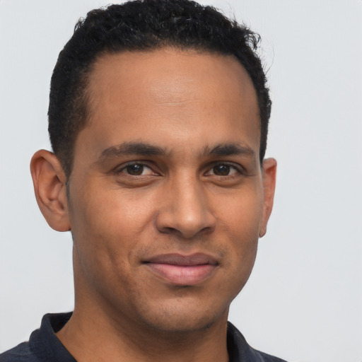 Joyful latino young-adult male with short  brown hair and brown eyes