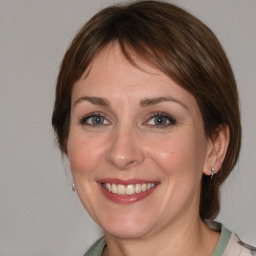 Joyful white young-adult female with medium  brown hair and blue eyes