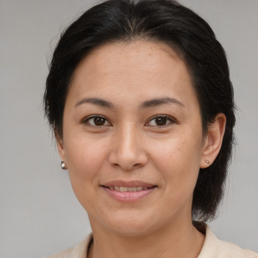 Joyful latino adult female with medium  brown hair and brown eyes