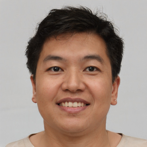 Joyful asian adult male with short  brown hair and brown eyes