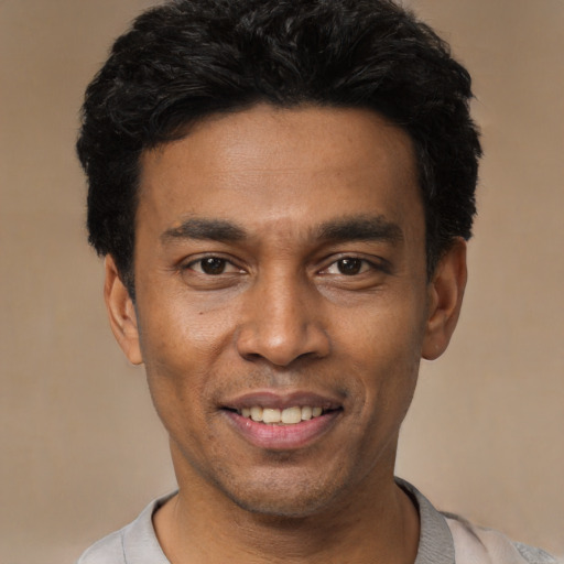 Joyful latino young-adult male with short  black hair and brown eyes