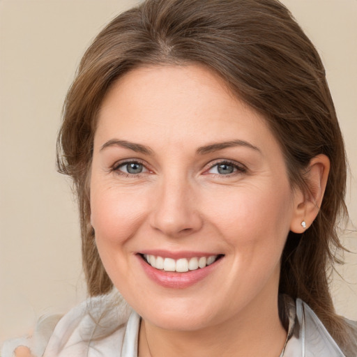 Joyful white young-adult female with medium  brown hair and blue eyes