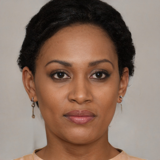 Joyful black young-adult female with short  brown hair and brown eyes