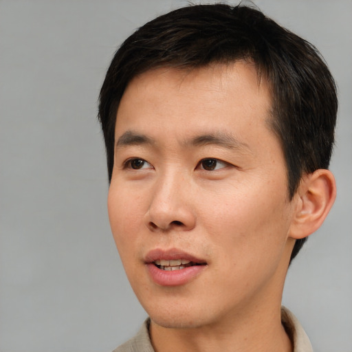 Joyful asian young-adult male with short  brown hair and brown eyes