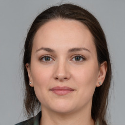 Joyful white young-adult female with long  brown hair and grey eyes