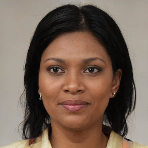 Joyful black young-adult female with medium  black hair and brown eyes
