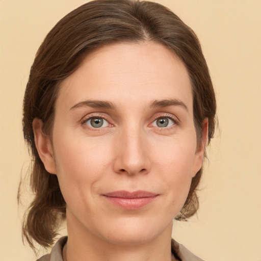 Joyful white young-adult female with medium  brown hair and grey eyes