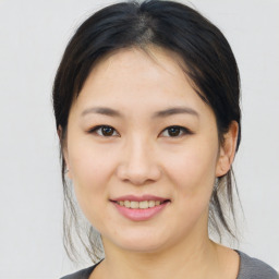 Joyful asian young-adult female with medium  brown hair and brown eyes