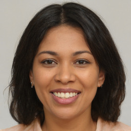 Joyful latino young-adult female with medium  brown hair and brown eyes