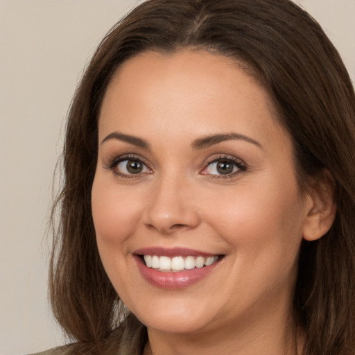 Joyful white young-adult female with long  brown hair and brown eyes