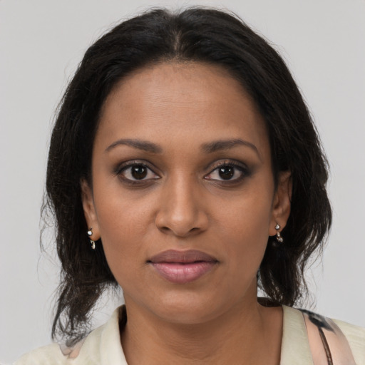Joyful black young-adult female with long  brown hair and brown eyes