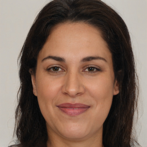 Joyful latino adult female with long  brown hair and brown eyes