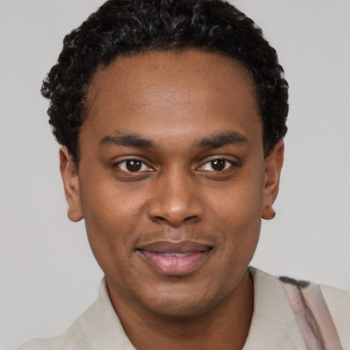 Joyful black young-adult male with short  black hair and brown eyes