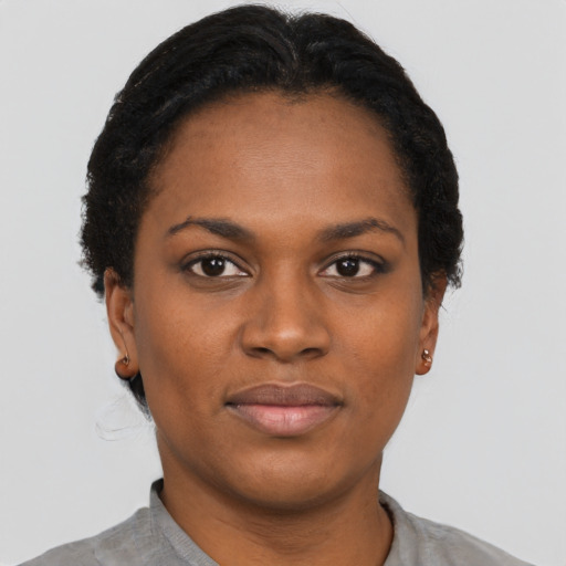 Joyful black young-adult female with short  black hair and brown eyes