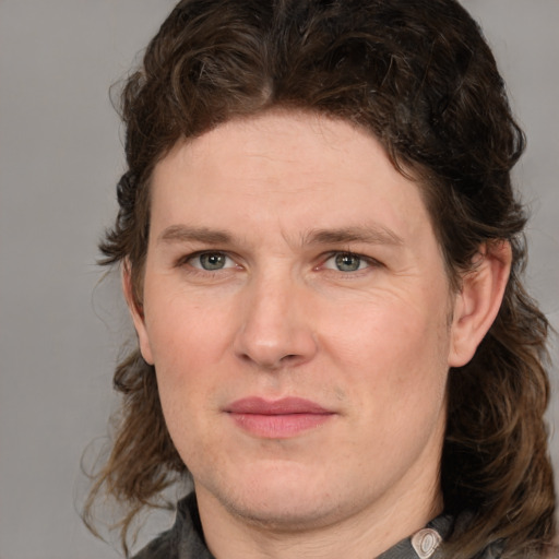 Joyful white adult male with medium  brown hair and green eyes