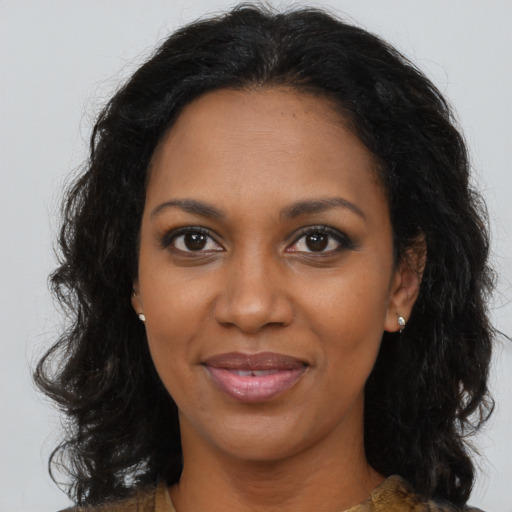 Joyful black young-adult female with long  brown hair and brown eyes