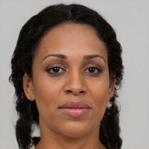 Joyful latino adult female with medium  brown hair and brown eyes