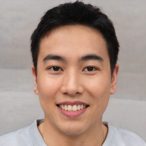 Joyful asian young-adult male with short  black hair and brown eyes