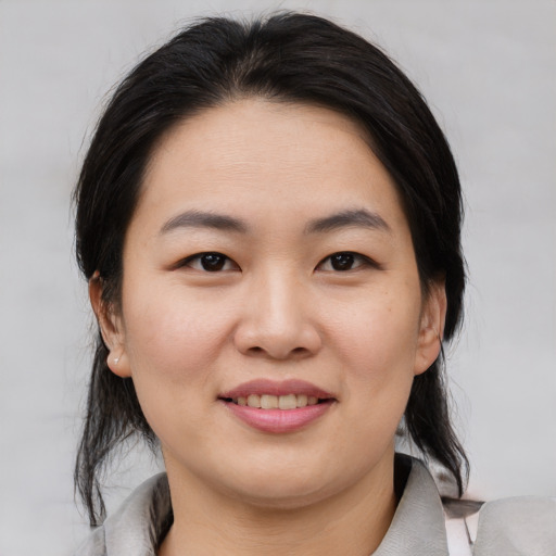 Joyful asian young-adult female with medium  brown hair and brown eyes