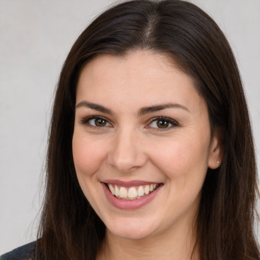 Joyful white young-adult female with long  brown hair and brown eyes