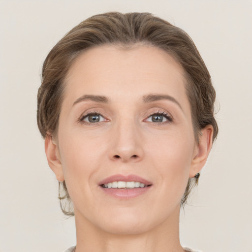 Joyful white young-adult female with medium  brown hair and grey eyes