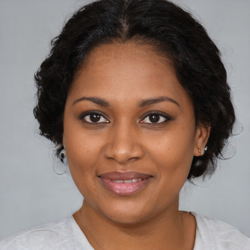 Joyful black young-adult female with medium  brown hair and brown eyes