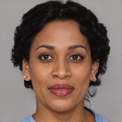 Joyful black adult female with short  black hair and brown eyes