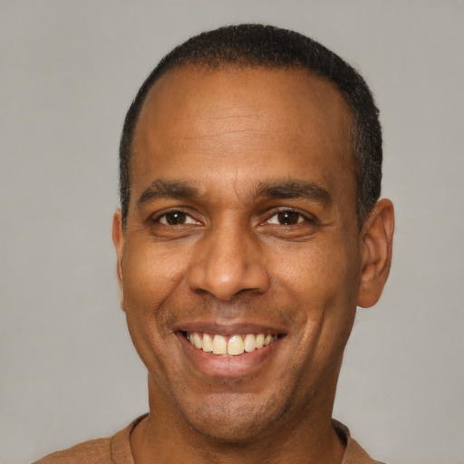 Joyful latino adult male with short  brown hair and brown eyes