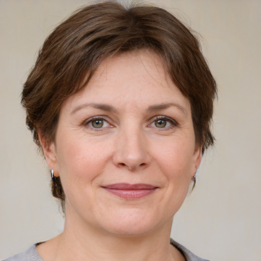 Joyful white adult female with medium  brown hair and grey eyes